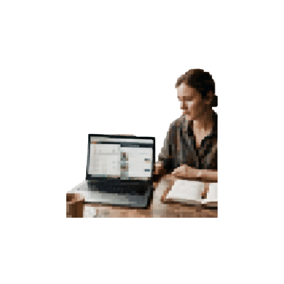A traveler comparing flight and hotel prices on a laptop next to a notebook with a trip itinerary